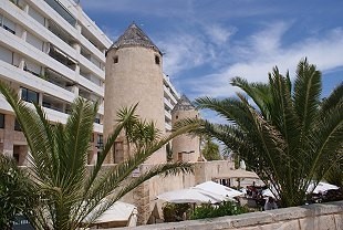 Mallorquinische Strandbar, im Hintergrund Appartementanlage mit Palmen